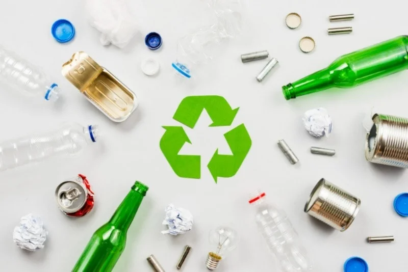 recycling symbol surrounded by various recyclable items