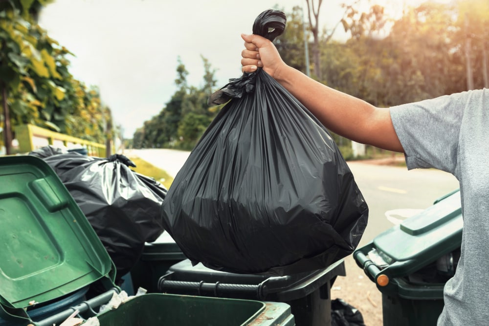 woman hand holding garbage black bag cleaning trash 1