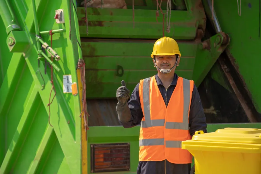 garbage collector happy male worker with dustbin street during day